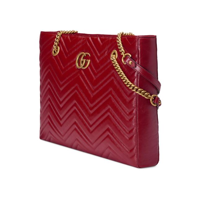 The Gucci GG Marmont Matelassé Leather Shoulder Bag in Red is a gorgeous leather bag with a tote silhouette which is accented by antique gold-tone hardware. Exquisite matelasse stitching accentuates the streamlined silhouette of a trim tote bag branded with antiqued double-G hardware inspired by an archival design.