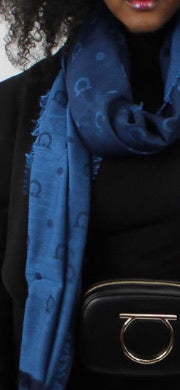 Keep warm and stay looking stylish in this scarf good for the winter or even as a shawl in warmer months.  Denim blue shades make it perfect for folding inside your bag to wear with jeans or something dressy.  Perfect for those air conditioned indoors and cool spring and summer nights.  Gancini Blue Libellula 60% Virgin wool, 28% Cashmere, 12% Silk 80" x 27" (203cm x 68.5cm) Comes in Ferragamo scarf box Product Code 525000 Made in Italy