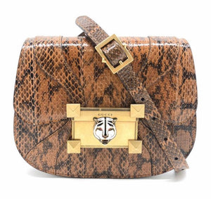 Looking to experience pure bliss from a bag? This snakeskin shoulder bag by Gucci is all you'll need! Elegantly designed in sturdy architecture, this bag has hard lines to contrast the soft blend of browns in the snakeskin. A polished gold clasp is detailed with a white ceramic tiger head for a striking design. 