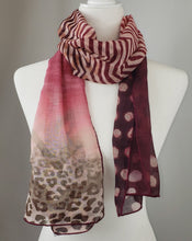 Load image into Gallery viewer, We are obsessed with this soft and luxurious scarf from Salvatore Ferragamo. A perfect blend of red and burgundy hues, this scarf is bold and bright, while maintaining a distinguished and fashionable feel. Tiger, zebra, and leopard prints are intricately placed in a gorgeous pattern that needs to be shown off!   Red, burgundy, and coral in an animal print 92% Modal, 8% Cashmere 60&quot; x 17&quot; (152.4cm x 43.18cm) Comes in Ferragamo scarf box Made in Italy